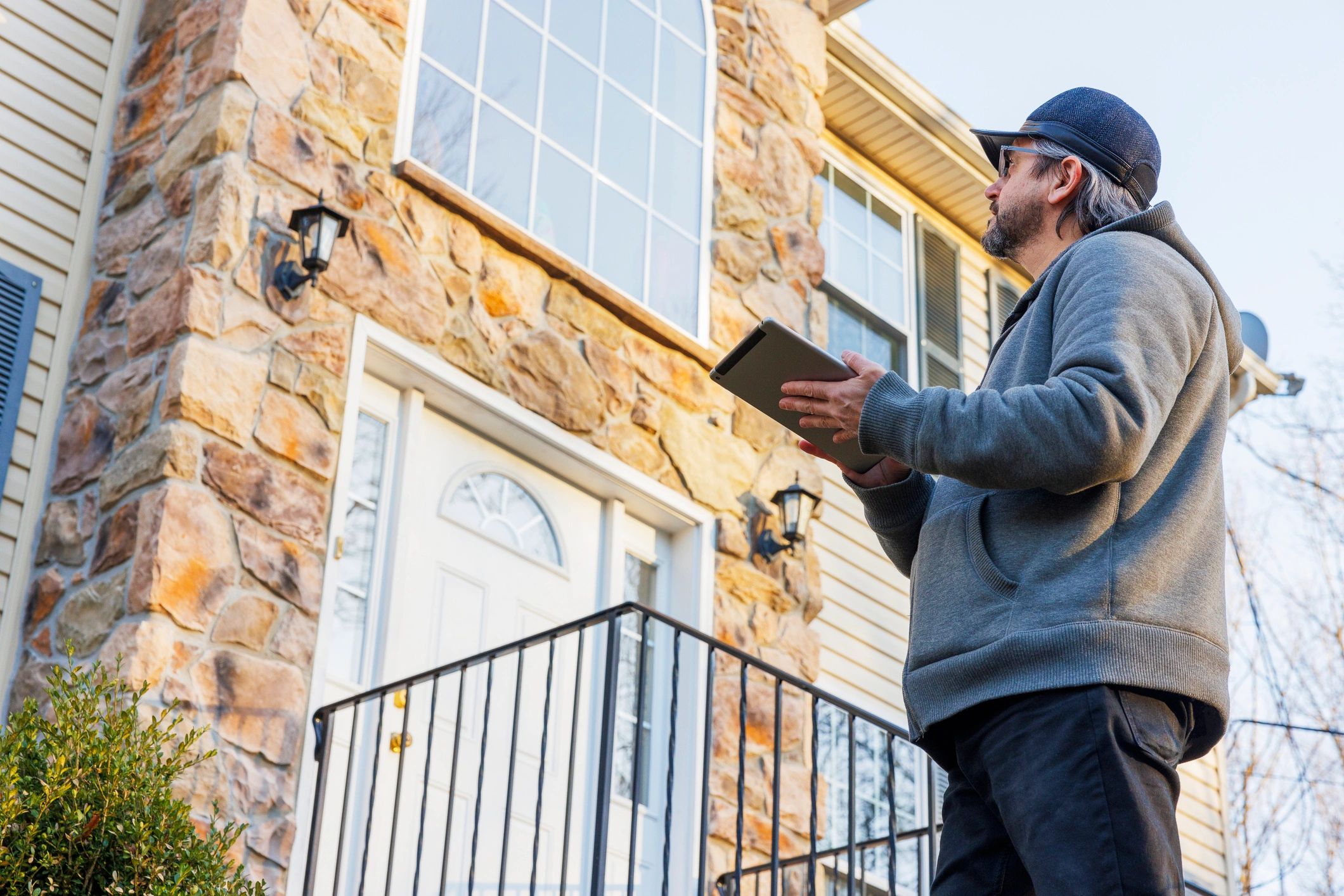 Inspector examining a home exterior from the porch